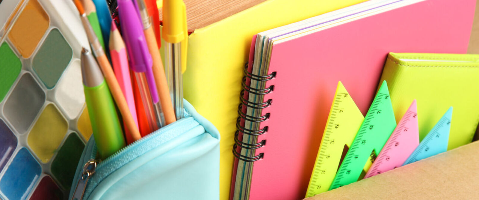 Open cardboard box filled with various school supplies.